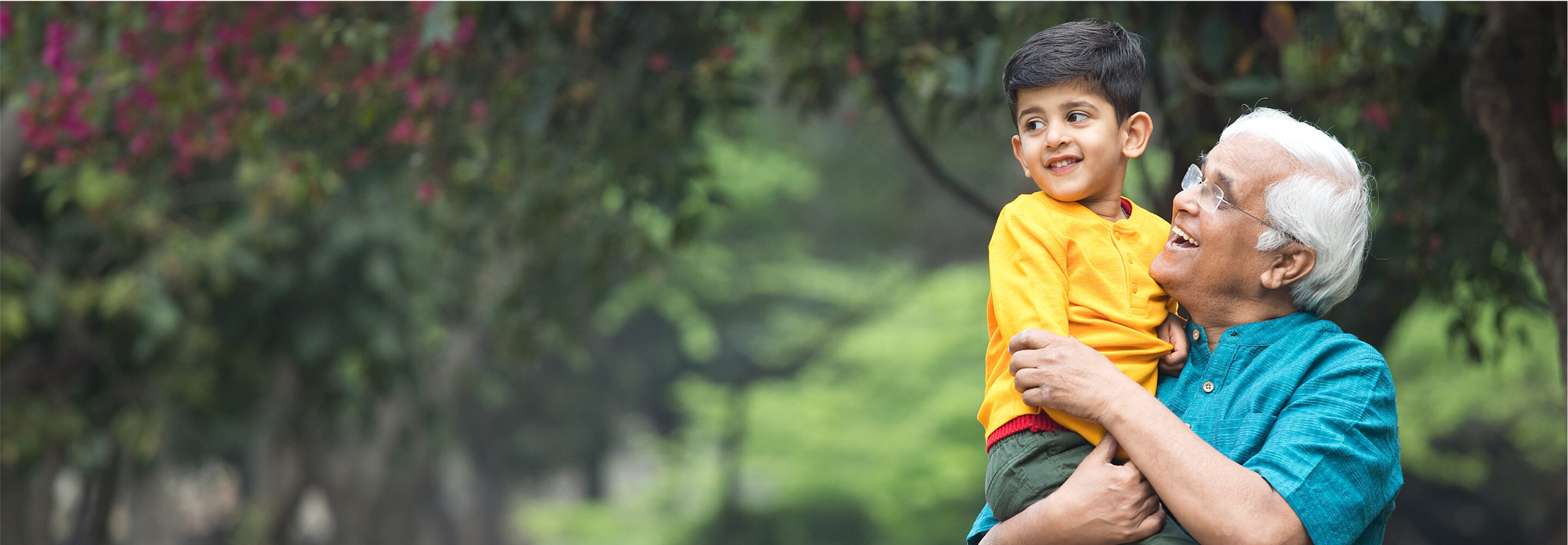 A older man holding a child happy about his HAE procedure