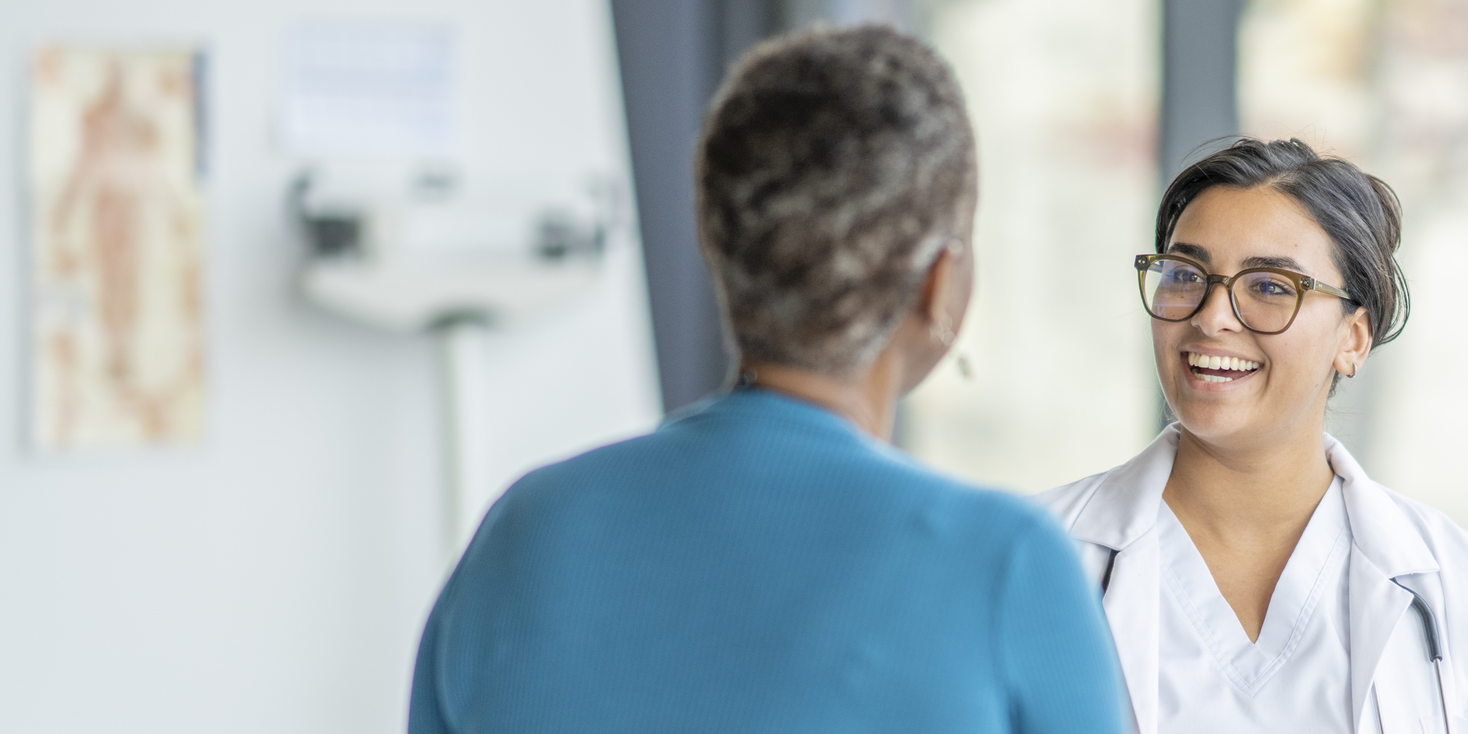 A woman and a healthcare worker discussing peripheral artery disease procedure 