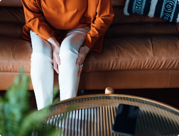 A woman rubbing her knees because of osteoarthritis pain