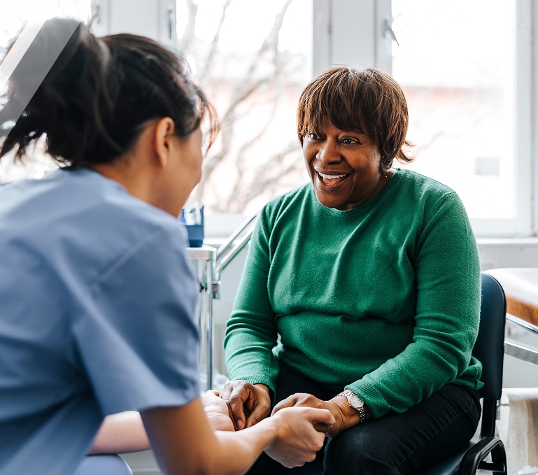A woman discussing genicular artery embolization, GAE with her doctor
